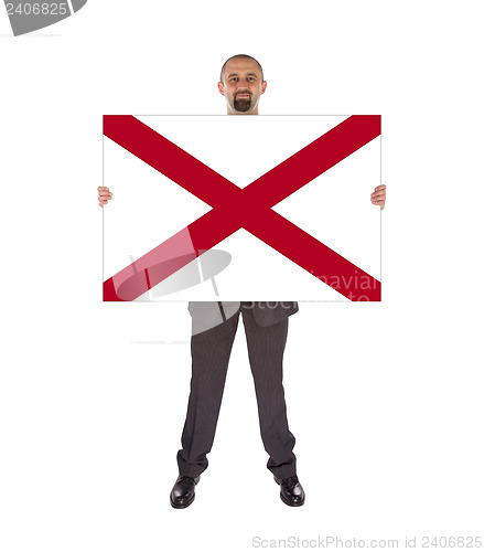 Image of Smiling businessman holding a big card, flag of Alabama