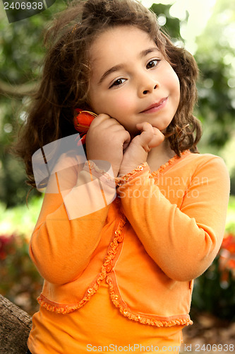 Image of Beautiful little girl holding a flower picked from the garden