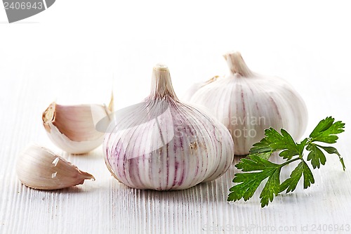 Image of garlic and parsley on a white wooden table
