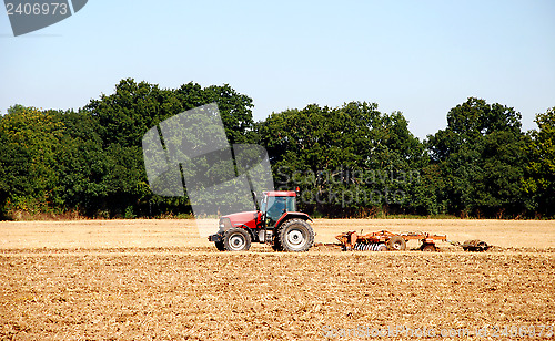 Image of Tractor and harrow cultivating the soil