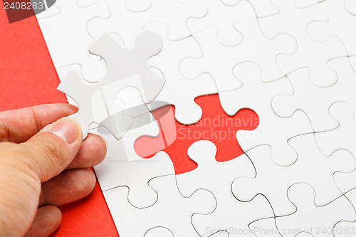 Image of Incomplete puzzle with missing piece on human hand