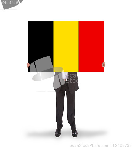 Image of Smiling businessman holding a big card, flag of Belgium