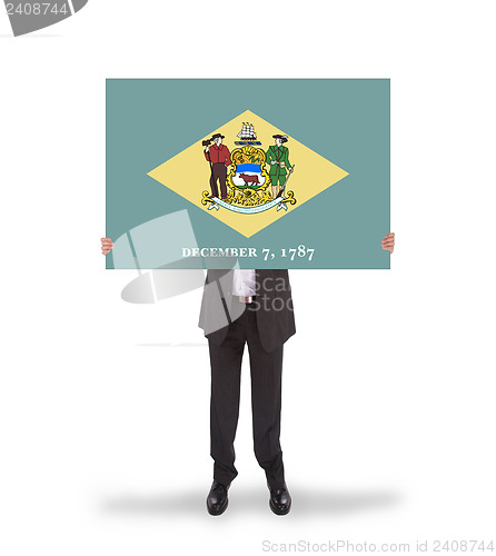 Image of Smiling businessman holding a big card, flag of Delaware