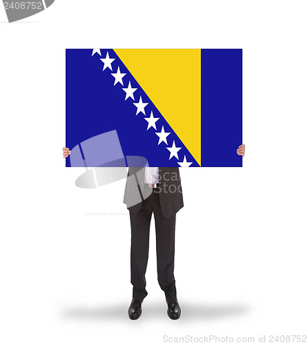 Image of Smiling businessman holding a big card, flag of Bosnia and Herze