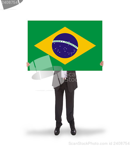 Image of Smiling businessman holding a big card, flag of Brazil