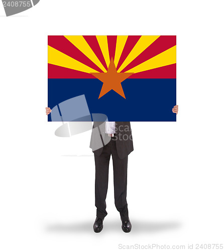 Image of Smiling businessman holding a big card, flag of Arizona