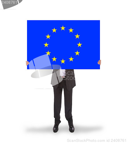 Image of Smiling businessman holding a big card, flag of the European Uni