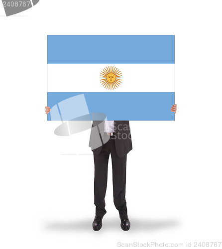 Image of Smiling businessman holding a big card, flag of Argentine