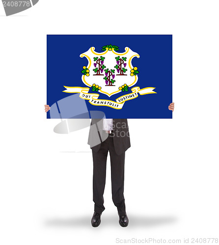 Image of Smiling businessman holding a big card, flag of Connecticut
