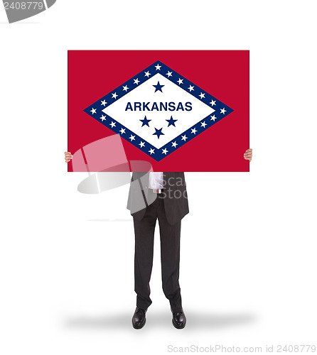 Image of Smiling businessman holding a big card, flag of Arkansas