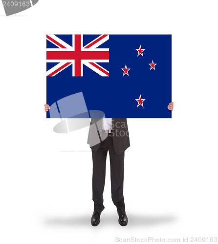 Image of Smiling businessman holding a big card, flag of New Zealand