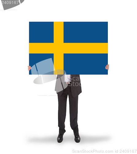 Image of Smiling businessman holding a big card, flag of Sweden