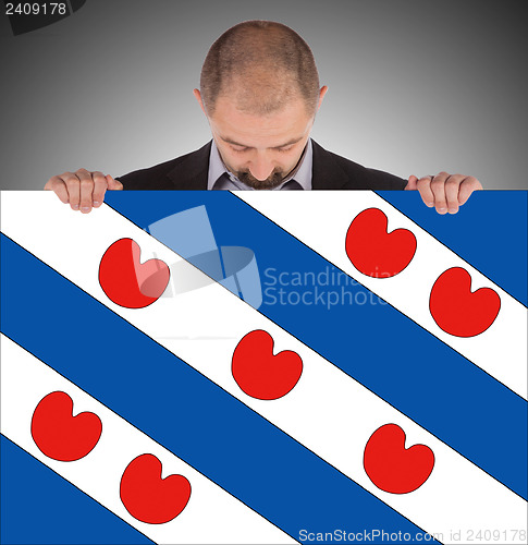 Image of Smiling businessman holding a big card, flag of the dutch provin