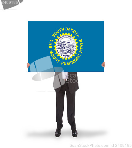 Image of Smiling businessman holding a big card, flag of South Dakota