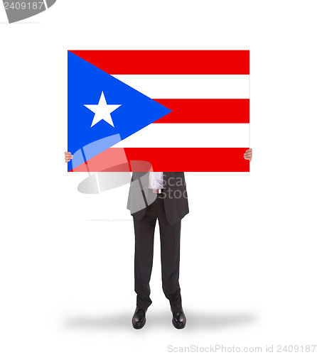 Image of Smiling businessman holding a big card, flag of Puerto Rico