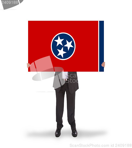 Image of Smiling businessman holding a big card, flag of Tennessee