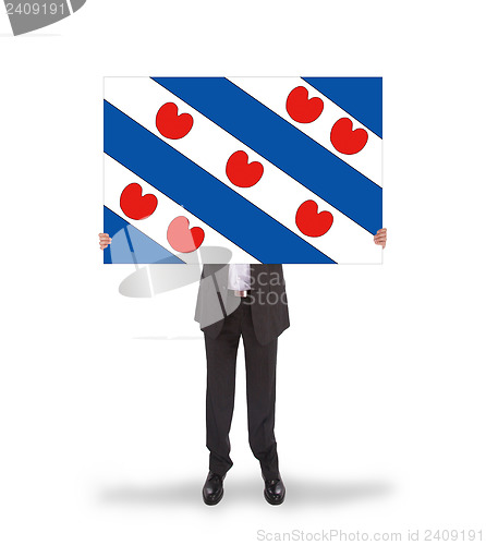 Image of Smiling businessman holding a big card, flag of the dutch provin