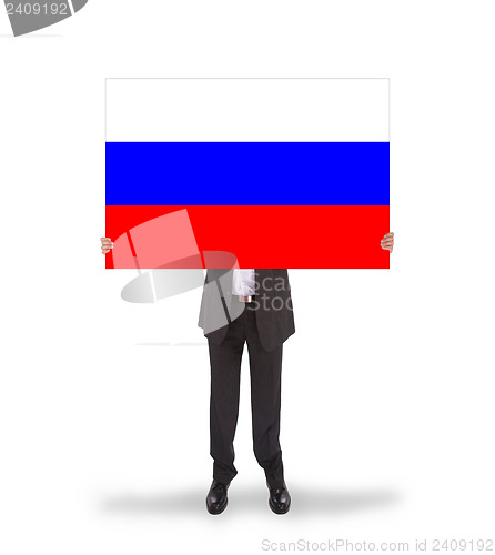 Image of Smiling businessman holding a big card, flag of Russia