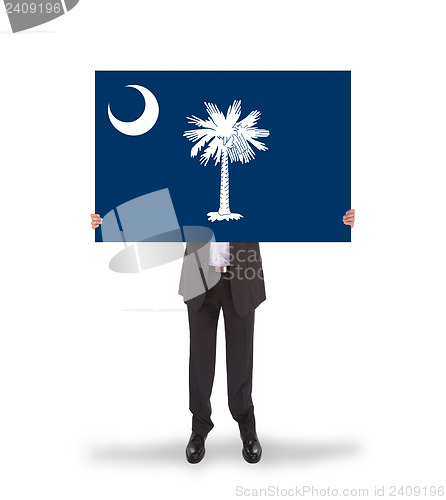 Image of Smiling businessman holding a big card, flag of South Carolina