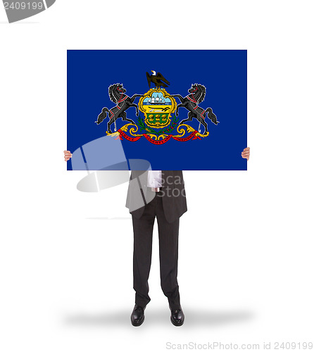 Image of Smiling businessman holding a big card, flag of Pennsylvania