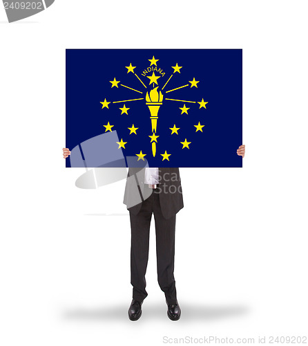 Image of Smiling businessman holding a big card, flag of Indiana