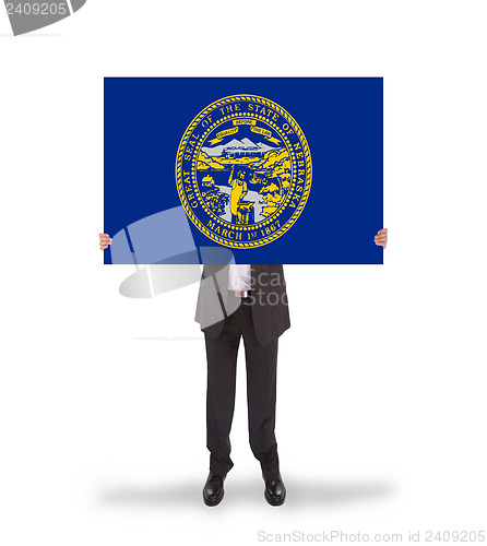 Image of Smiling businessman holding a big card, flag of Nebraska