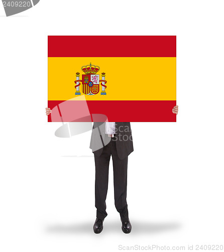 Image of Smiling businessman holding a big card, flag of Spain