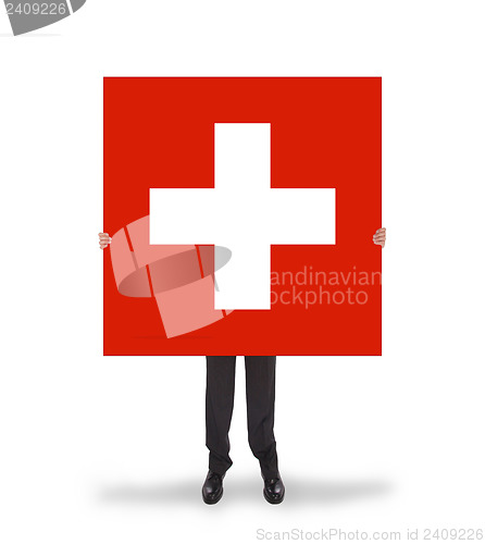 Image of Smiling businessman holding a big card, flag of Switzerland