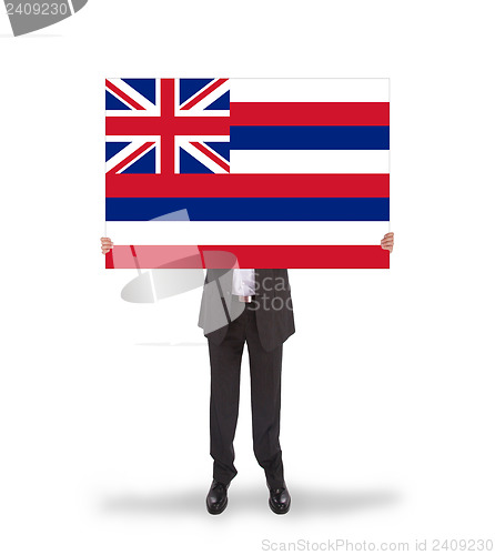 Image of Smiling businessman holding a big card, flag of Hawaii