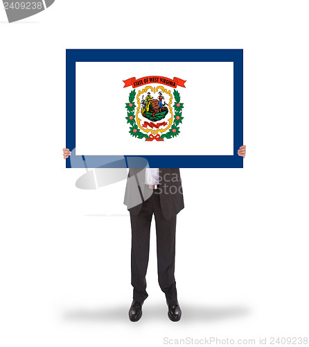 Image of Smiling businessman holding a big card, flag of West Virginia