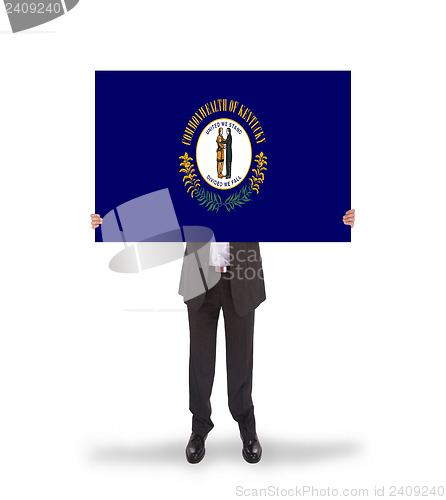 Image of Smiling businessman holding a big card, flag of Kentucky