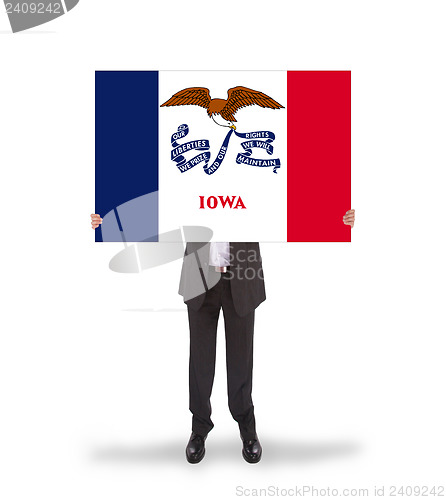 Image of Smiling businessman holding a big card, flag of Iowa
