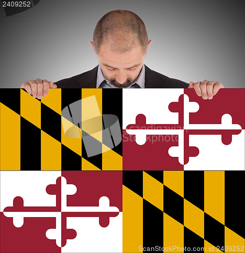 Image of Smiling businessman holding a big card, flag of Maryland