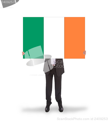 Image of Smiling businessman holding a big card, flag of Ireland