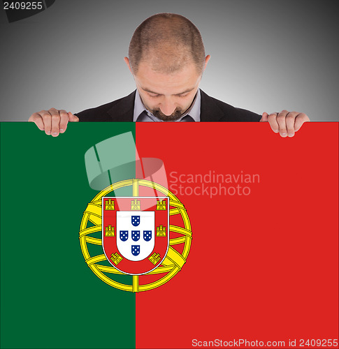 Image of Smiling businessman holding a big card, flag of Portugal