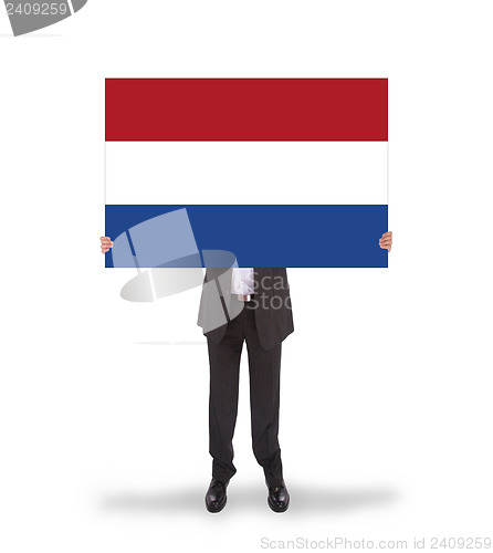 Image of Smiling businessman holding a big card, flag of the Netherlands