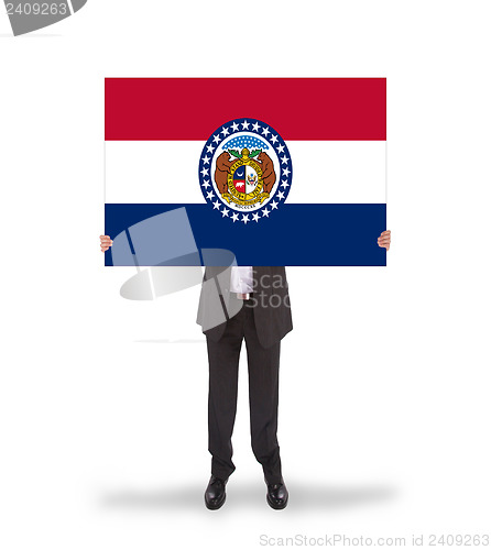 Image of Smiling businessman holding a big card, flag of Missouri