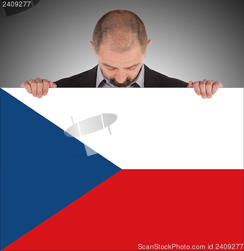 Image of Smiling businessman holding a big card, flag of the Czech Republ
