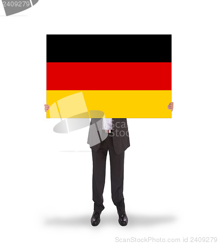 Image of Smiling businessman holding a big card, flag of Germany