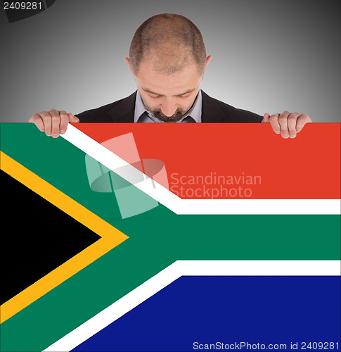 Image of Smiling businessman holding a big card, flag of South Africa