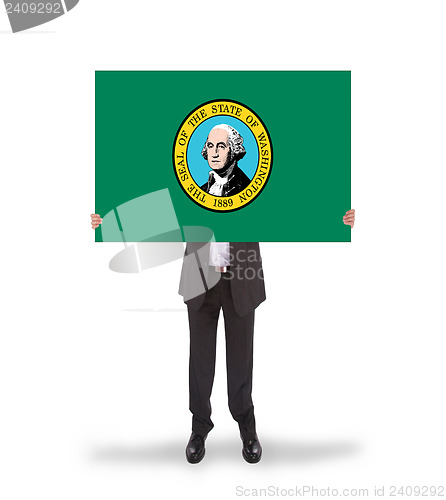 Image of Smiling businessman holding a big card, flag of Washington