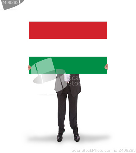 Image of Smiling businessman holding a big card, flag of Hungary