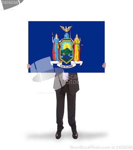 Image of Smiling businessman holding a big card, flag of New York
