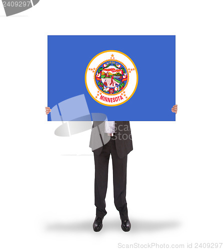 Image of Smiling businessman holding a big card, flag of Minnesota