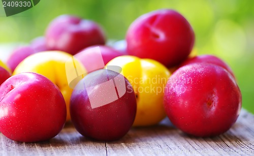 Image of Ripe plums on wooden table