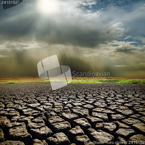 Image of dramatic sky with sun over drought earth