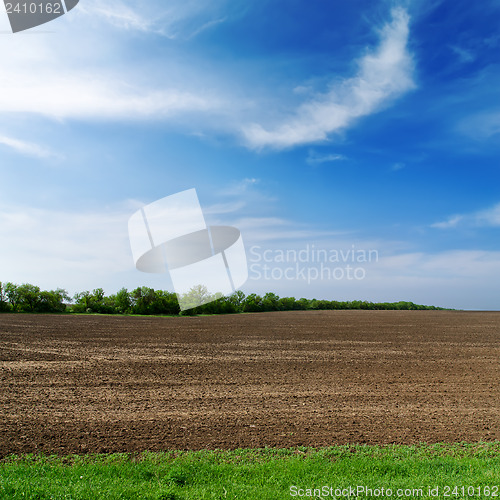 Image of black spring field and cloudy sky