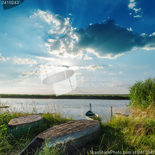 Image of sunset over river with boats