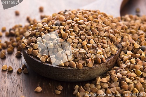 Image of Buckwheat seeds on wooden spoon in closeup 