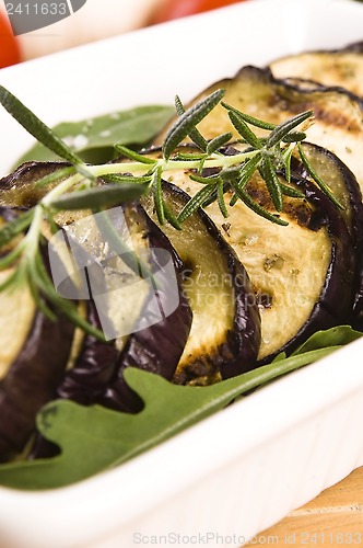 Image of Grilled eggplant slices on a plate with fresh rosemary